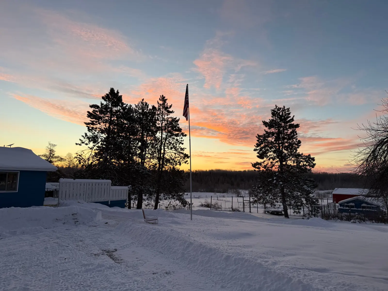 Sunset over the snowy homestead, the flag flying beside the office